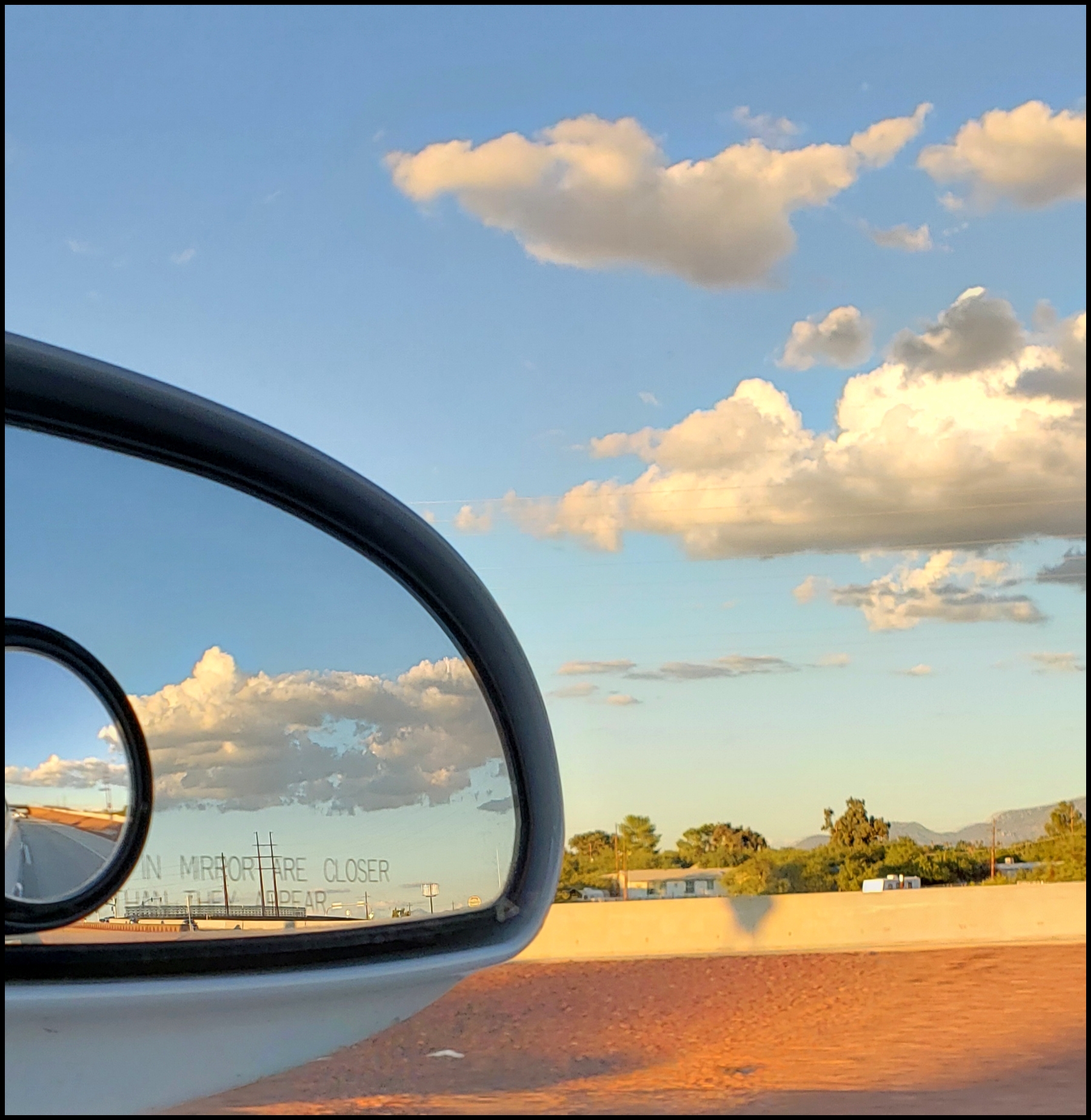 Sunset clouds in the car's rearview mirror