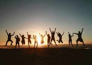 Silhouette of 12 people in a line, jumping for joy