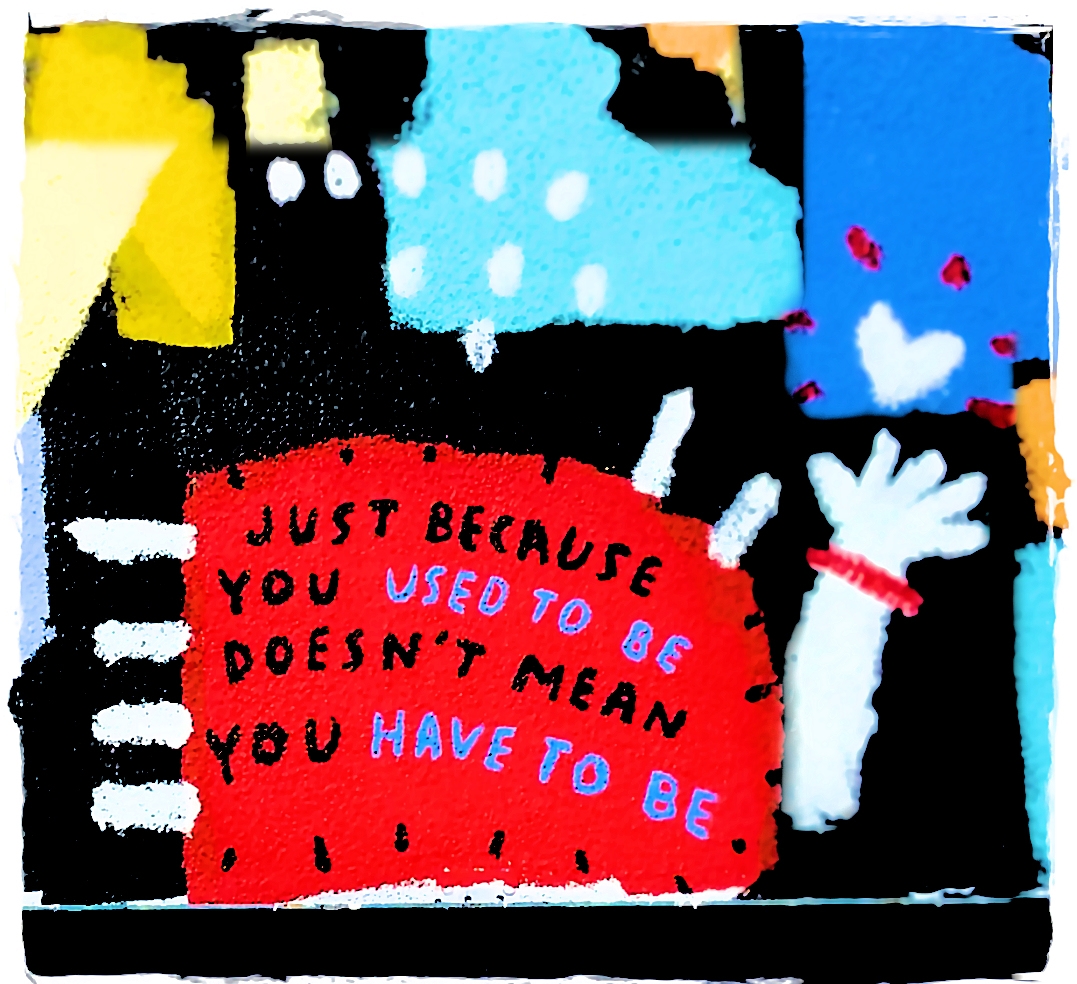 Shapes and colors painted on a wall. Text says "Just because you used to be doesn't mean you have to be."