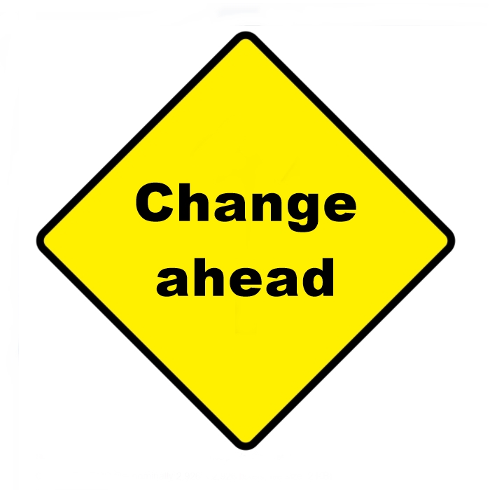 Yellow road sign with black letters saying Change Ahead