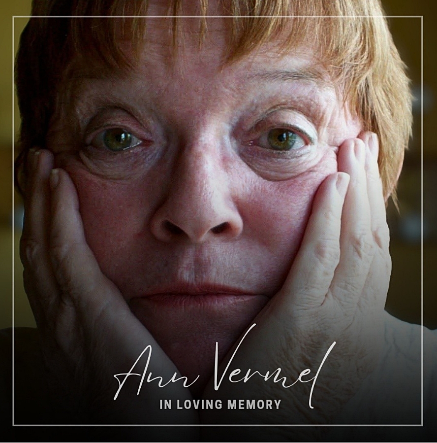 Close-up Photo of Ann Vermel. A white woman of a certain age, red hair, pink cheeks, holding her head in her hands. The text overlay says, "Ann Vermel, in loving memory."