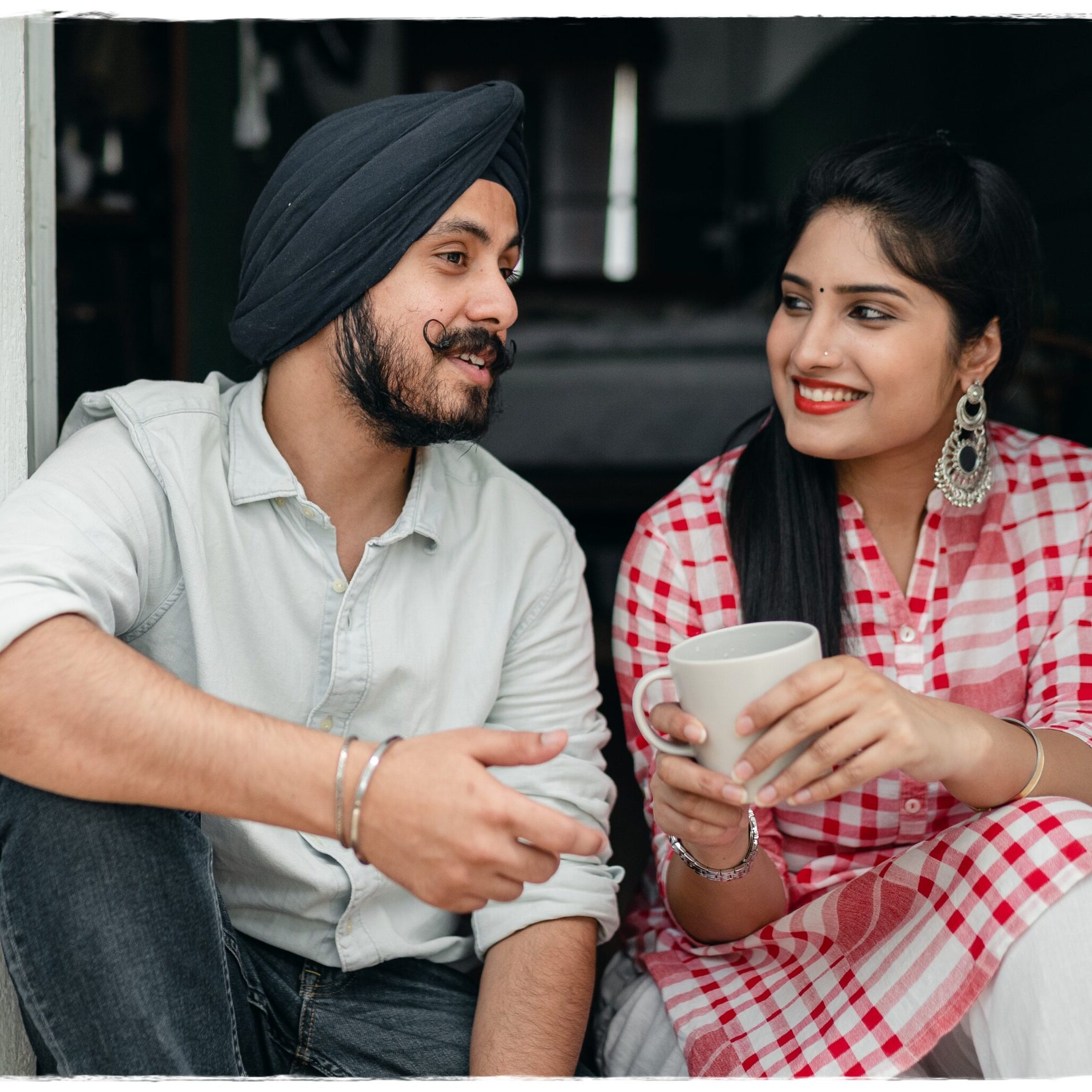 Man and woman sitting in a doorway, chatting.